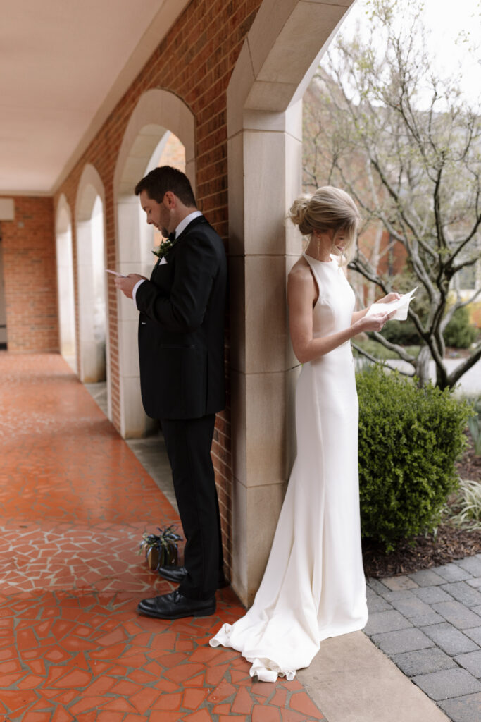 bride and groom reading letters and facing away from each other during their first touch