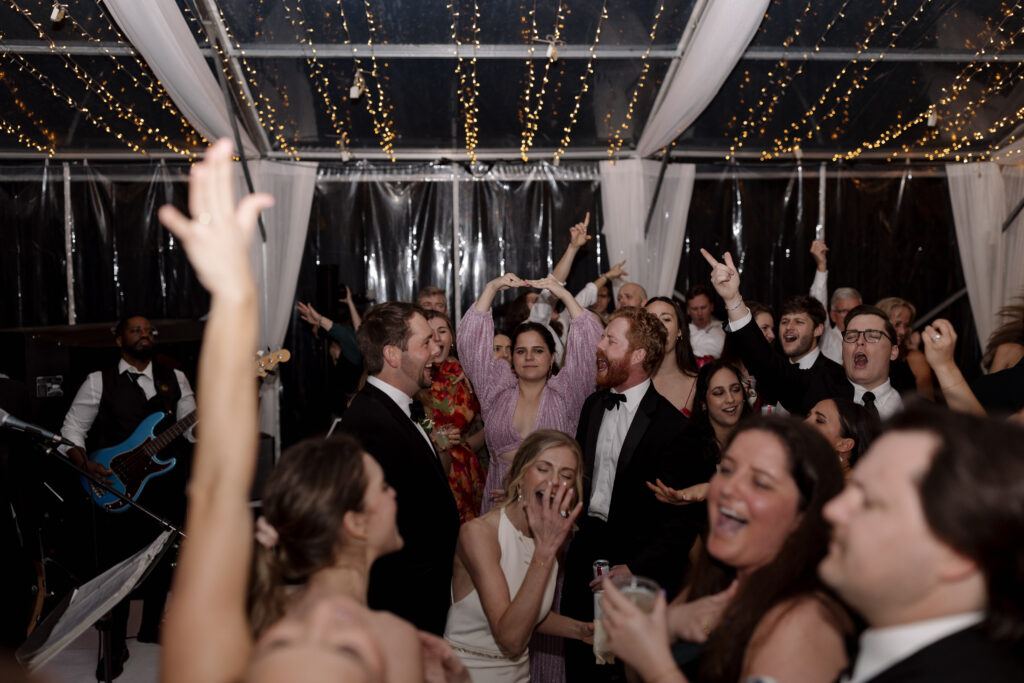 Bride, groom, and wedding party dance on the dance floor during their reception