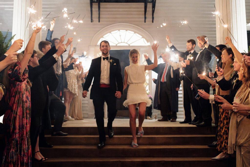 Bride and groom walking out of their wedding with everyone holding sparklers