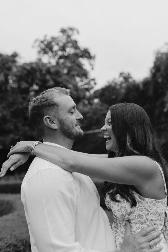 Girl's arm's around her fiance while she is laughing