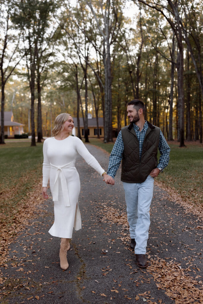 couple walking and holding hands during a fall engagement session.