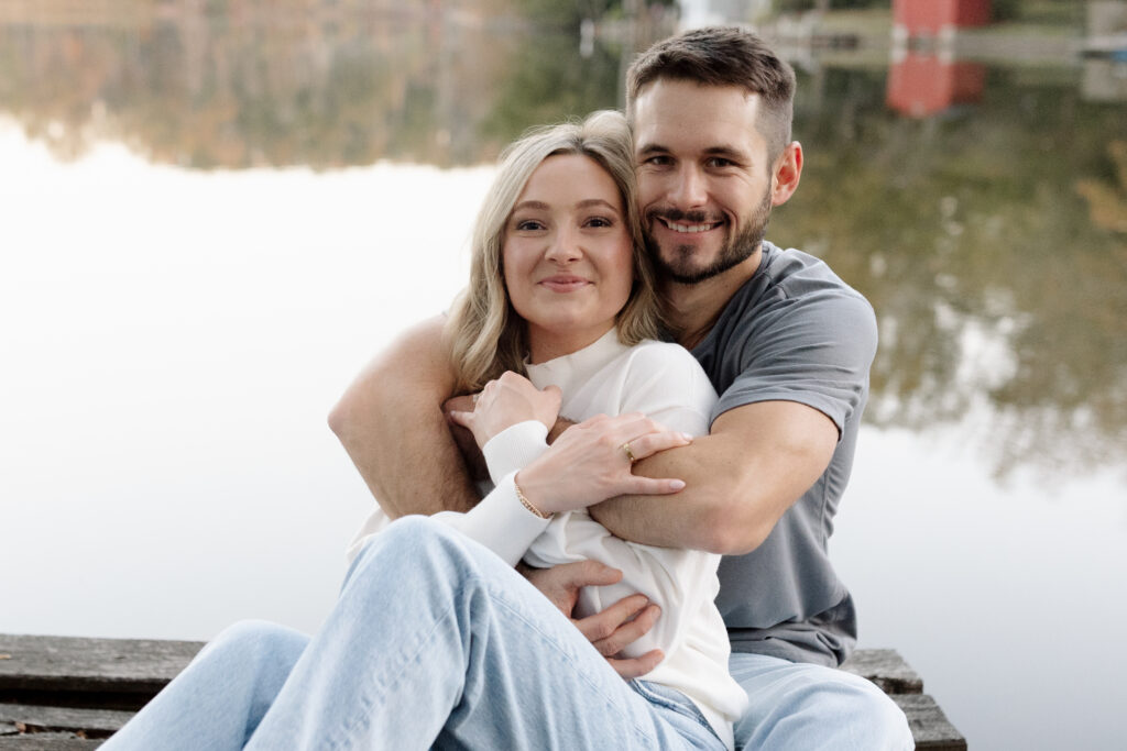 Couple sitting on the dock hugging each other