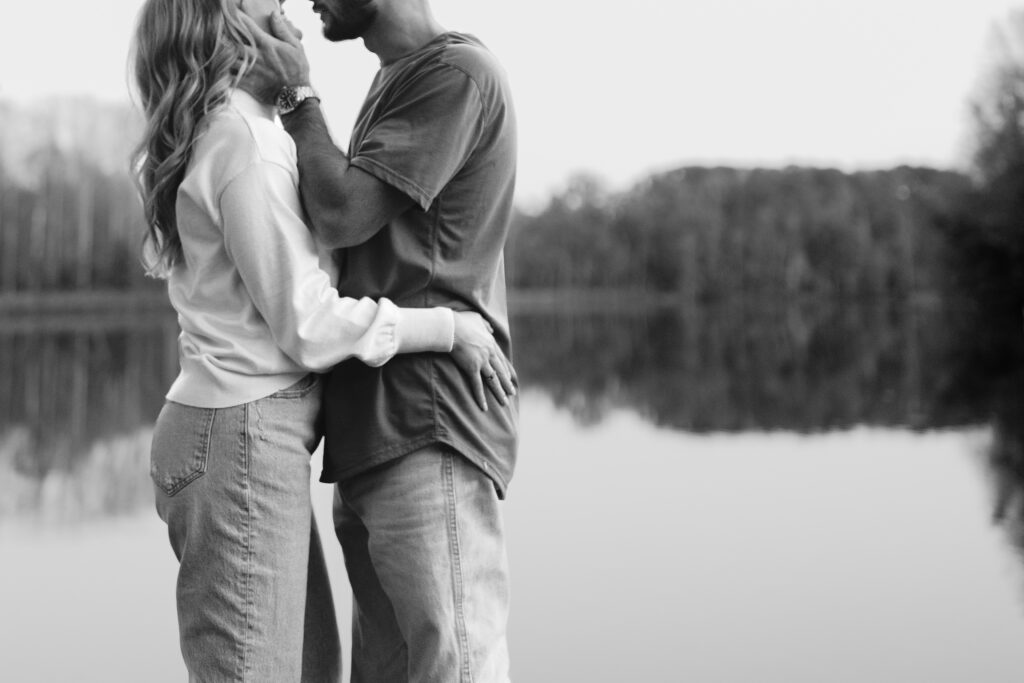 couple embracing each other by the lake during their engagement session