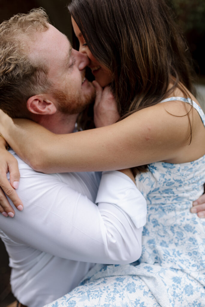 close up of guy pulling in his girl with her chin to kiss her