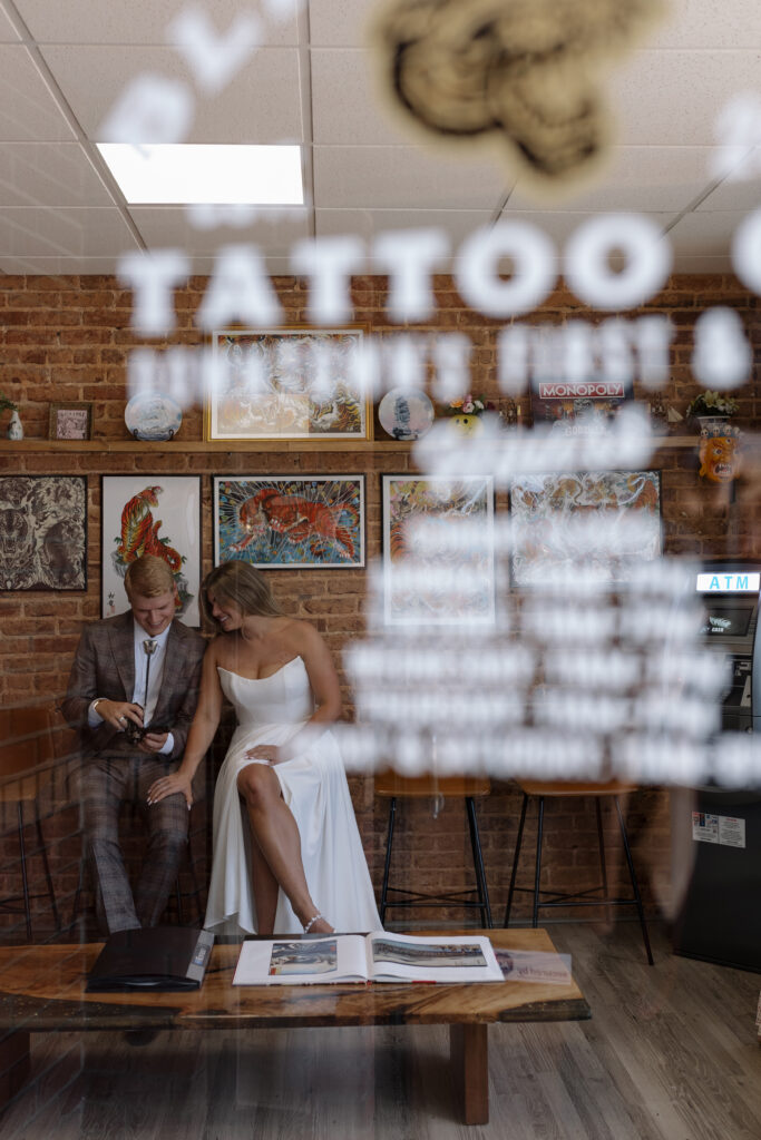 bride and groom through a window of a tattoo shop in Greenville