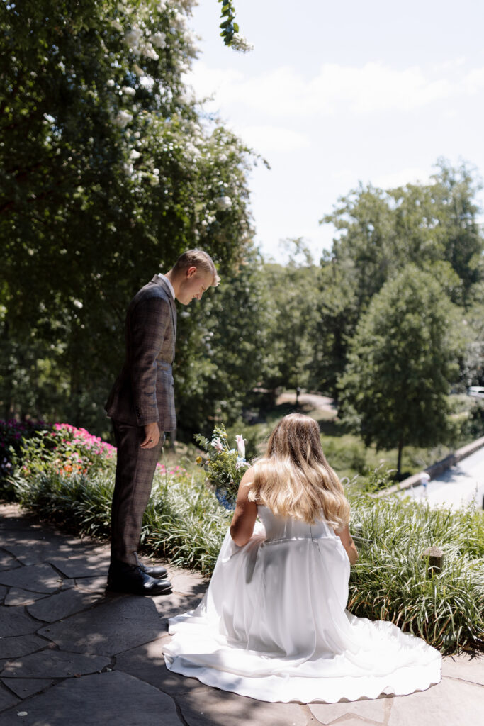 bride looking at the sign while groom stands above her