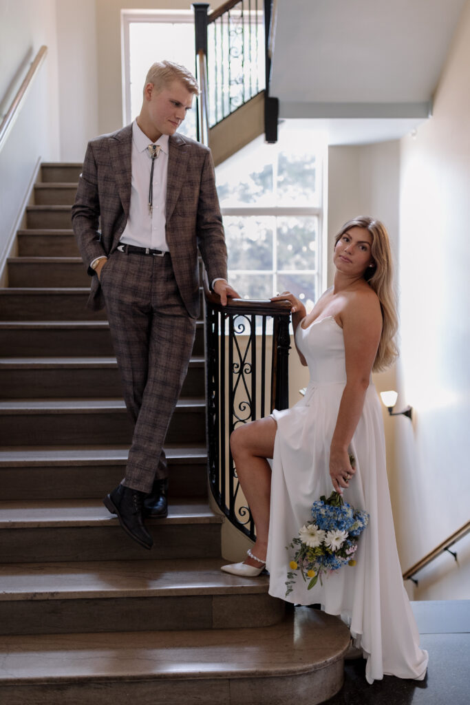 Groom looking down at the bride at the bottom of the steps