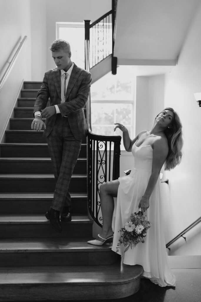 Groom fixes his suit while the bride moves her hair on steps