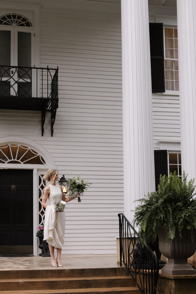 bride standing outside her wedding venue holding flowers