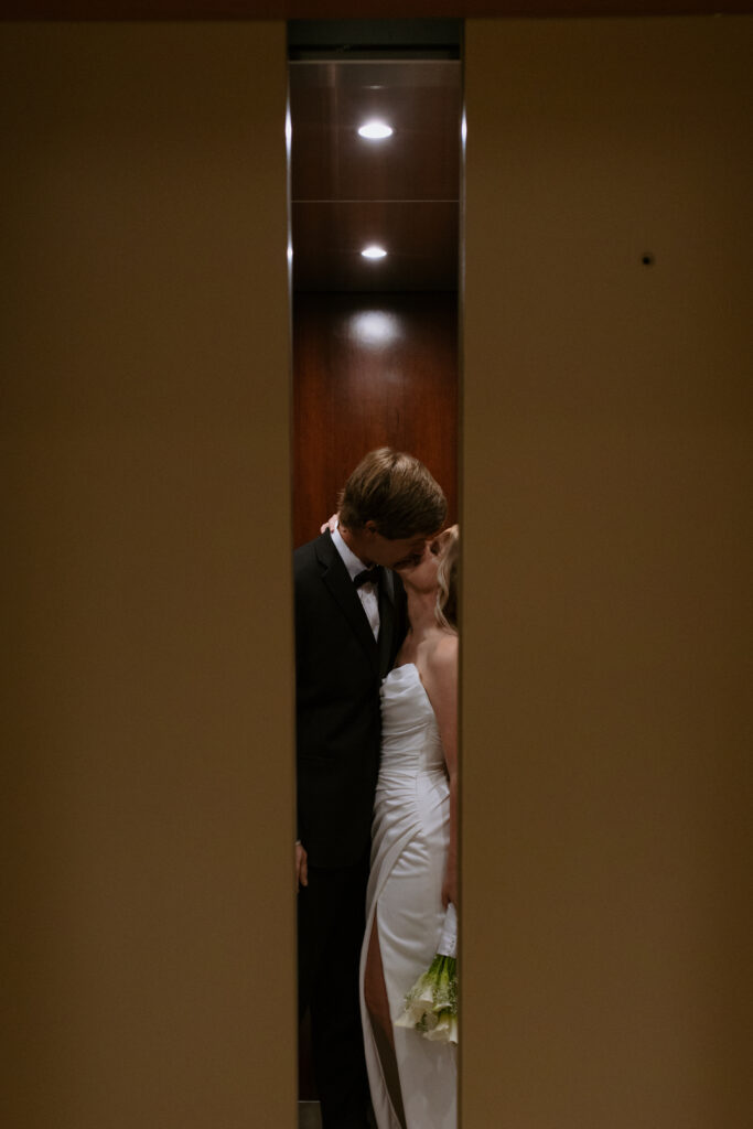 Bride and groom kissing in the elevator after their elopement as the doors close