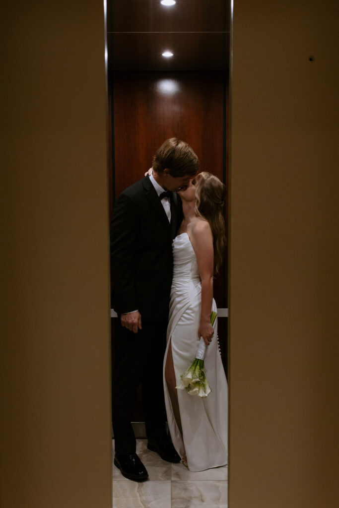 Bride and groom kissing in the elevator after their elopement as the doors close