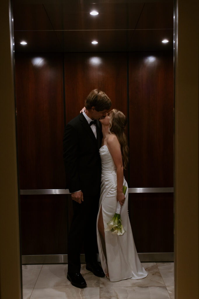 Bride and groom kissing in the elevator after their elopement as the doors close