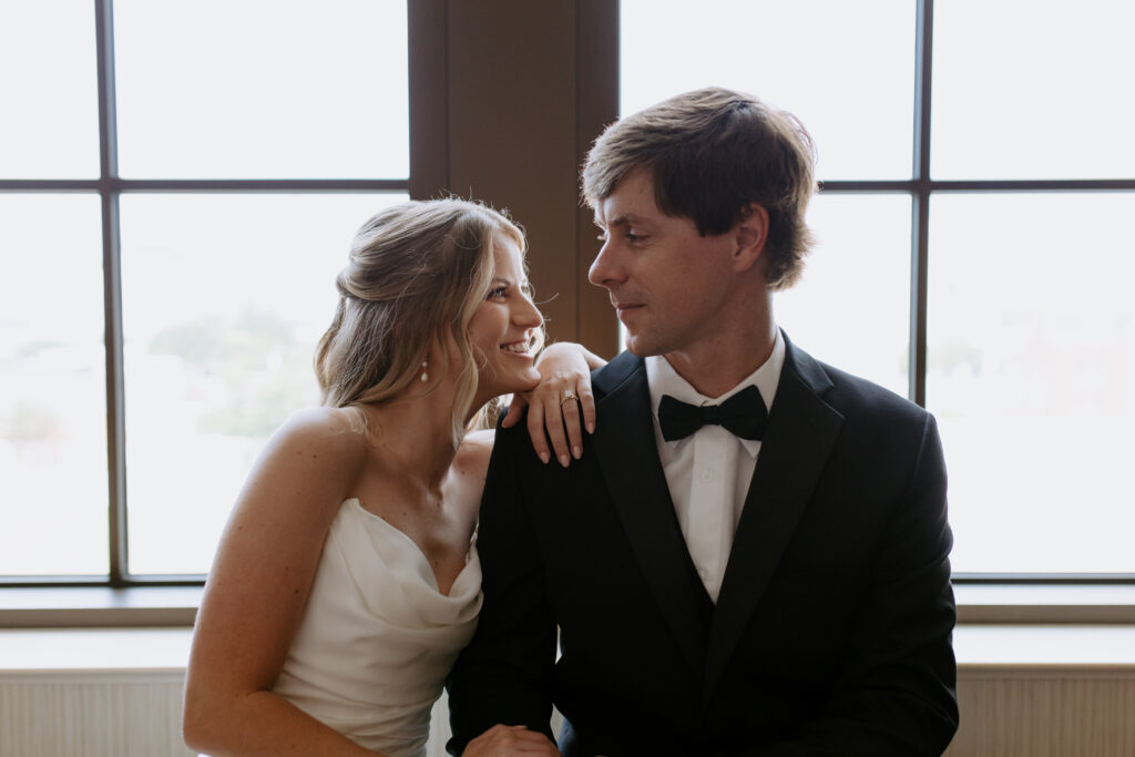 Bride hugging groom by the window after their elopement in spartanburg, sc. 