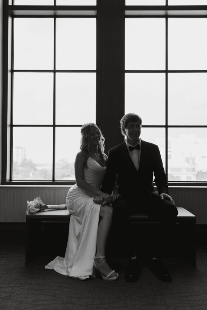 Bride and groom posing by the window at the spartanburg county courthouse.