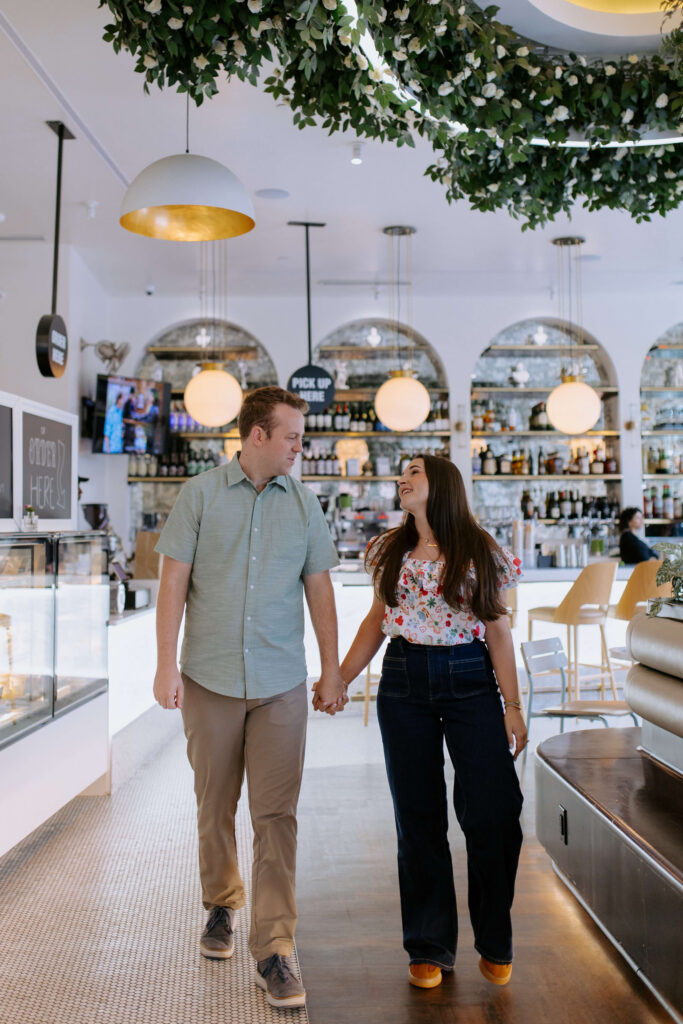 couple in greenville sc walking hand in hand in a coffee shop