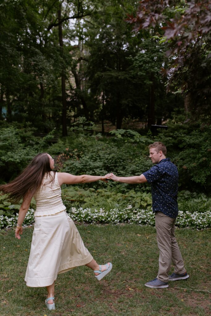 couple dancing with stretched out arms in the park