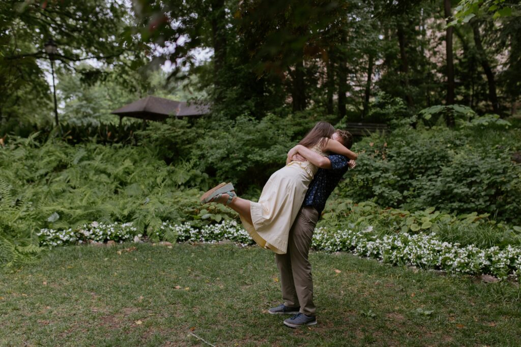 woman jumping into man's arms in falls park in greenville sc