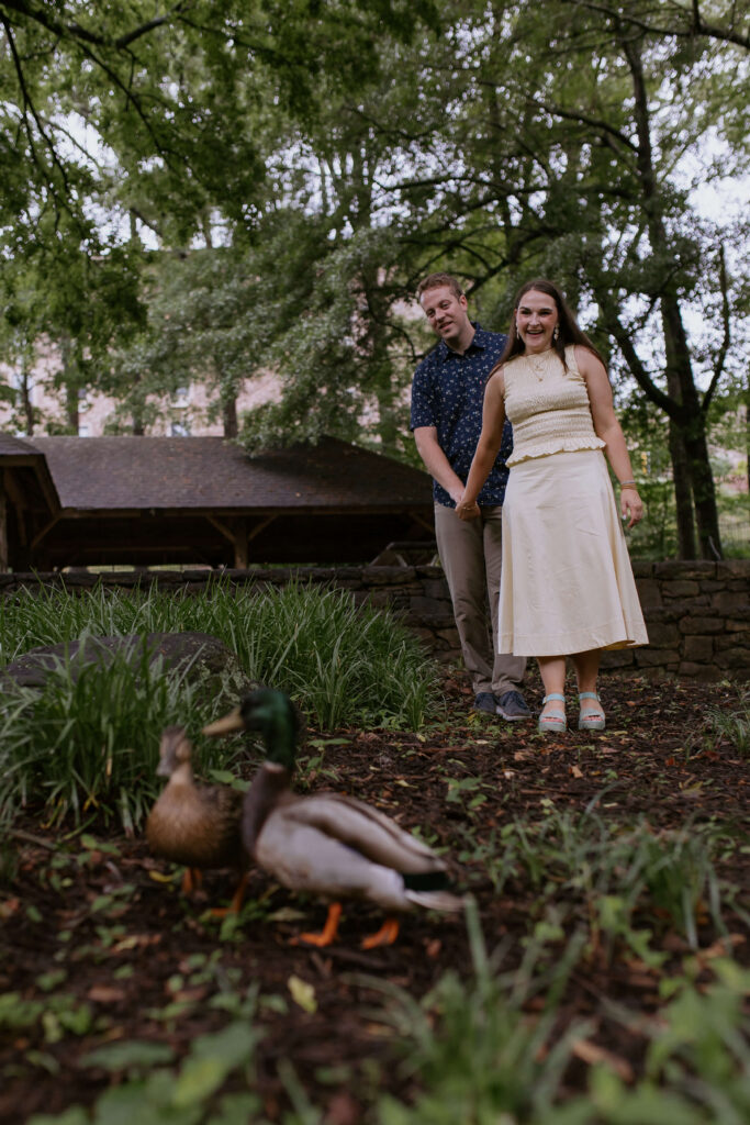couple holding hands while they watch the ducks in falls park