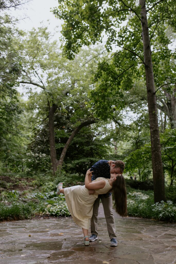 man dipping a woman while kissing her in falls park